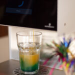 Ein Cocktailglas unter einem Cocktailautomaten