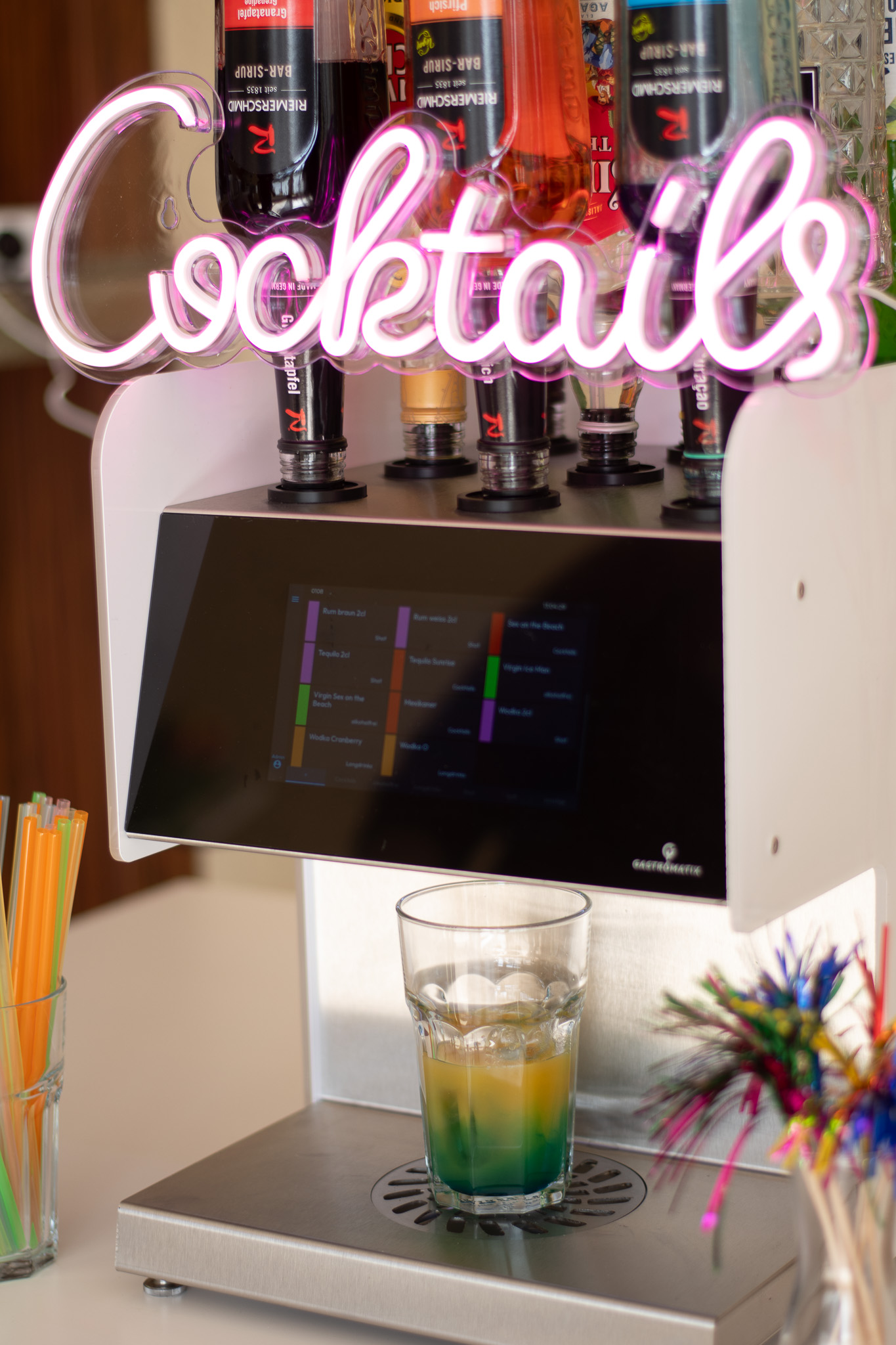 Eine Cocktailmaschine mit einem grünen fertigen Cocktail